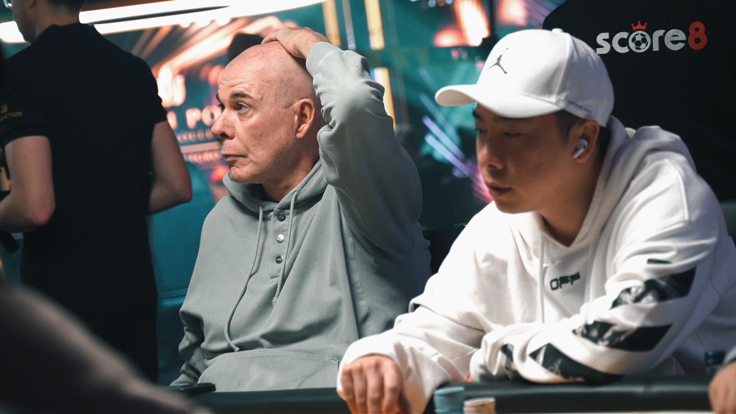Players focused at a Triton Montenegro poker table with Score8 branding behind them